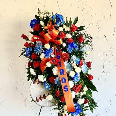 Tall standing spray of red, blue, and white flowers with orange ASTROS ribbon and baseball sign on an easel
