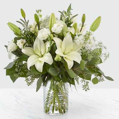 White lilies and roses in a clear glass vase