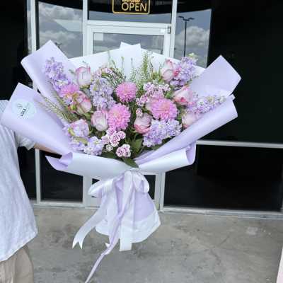 Lavender bouquet with pink roses and pink daisies wrapped in pastel paper