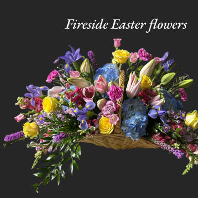 Basket arrangement of colorful flowers with Easter wording above