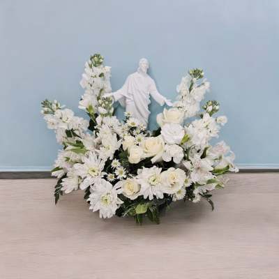 White floral arrangement with a religious statue centerpiece