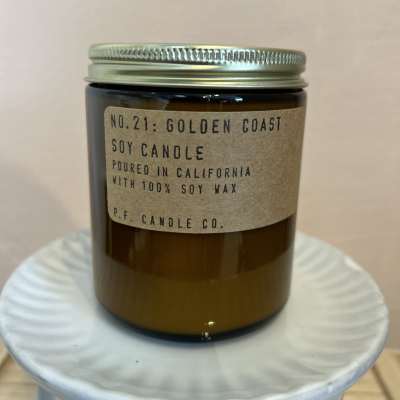 Amber jar candle with a metal lid and paper label