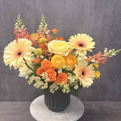 Colorful mixed bouquet in a dark vase with gerberas and roses