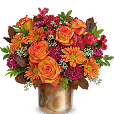 Orange roses and daisies in a bronze vase