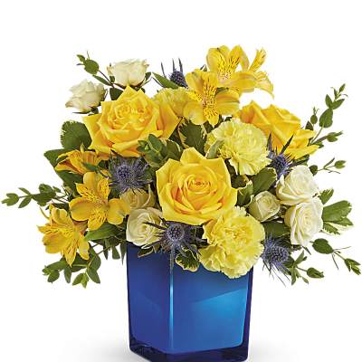 Yellow and white roses in a blue glass vase