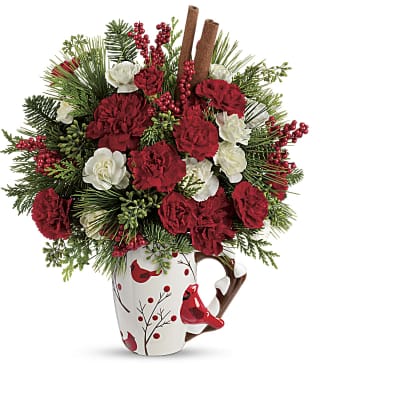 Red and white carnations in a holiday mug with pine and berries