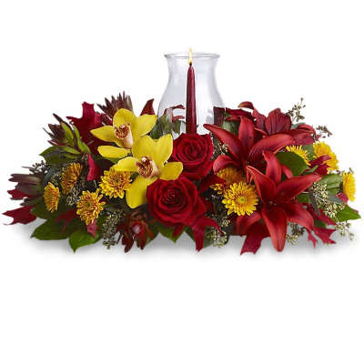 Red and yellow floral centerpiece with a glass candle holder