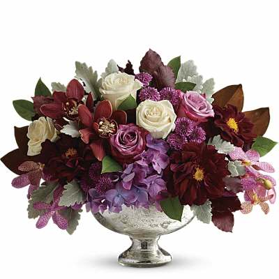 Mixed bouquet of roses, orchids, and hydrangeas in a silver pedestal vase