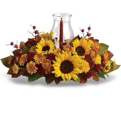 Sunflower and chrysanthemum centerpiece with a candle in a glass vase
