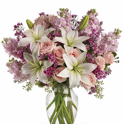 Pink roses and white lilies in a clear glass vase