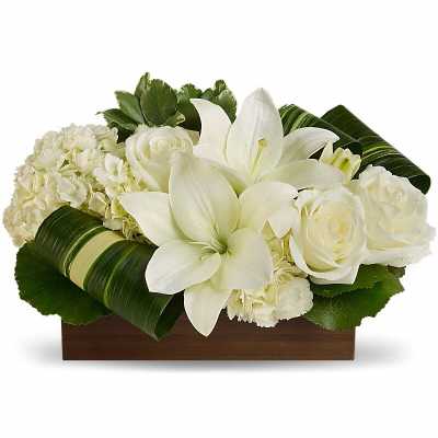 White lilies and roses arranged in a wooden box