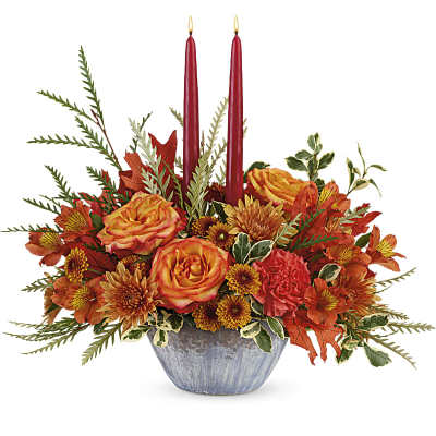 Autumn floral arrangement with red candles in a blue vase