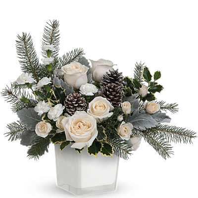 Cream roses and white carnations in a clear square vase with pinecones