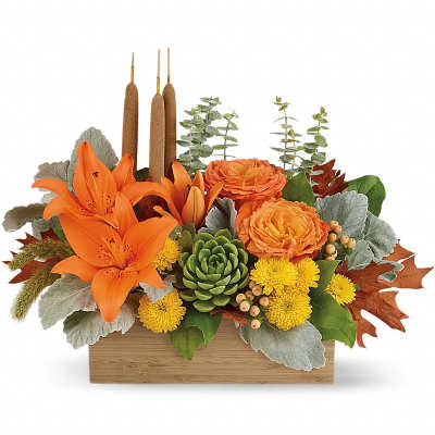 Orange lilies and mums in a wooden box with candles