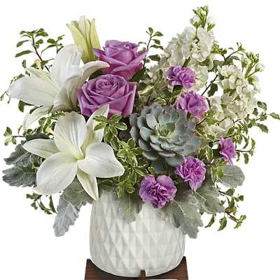 White lilies and purple roses in a white vase with a succulent
