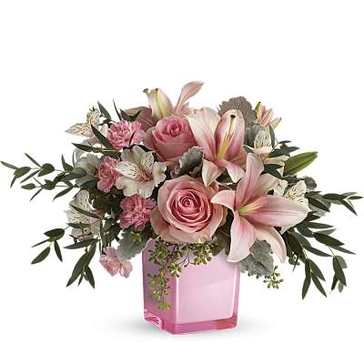 Pink roses and lilies arranged in a pink glass vase