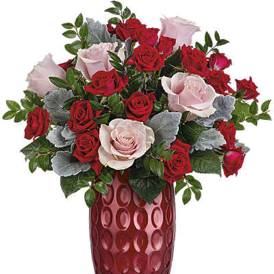 Red and pale pink roses in a red glass vase