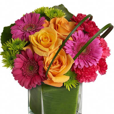 Colorful bouquet of roses, gerbera daisies, and carnations in a glass vase