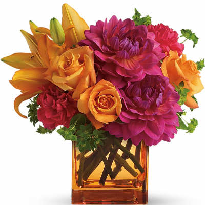 Orange and magenta flowers arranged in an amber glass vase