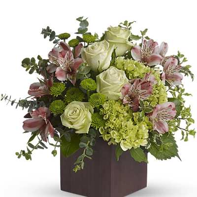 Arrangement of white roses, pink alstroemeria, and green blooms in a square vase