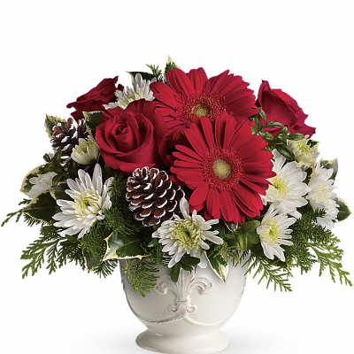 Red gerberas and roses in a white vase with white daisies and pinecones