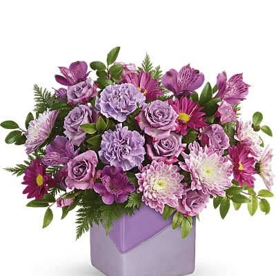 Purple and pink mixed bouquet in a lavender square vase