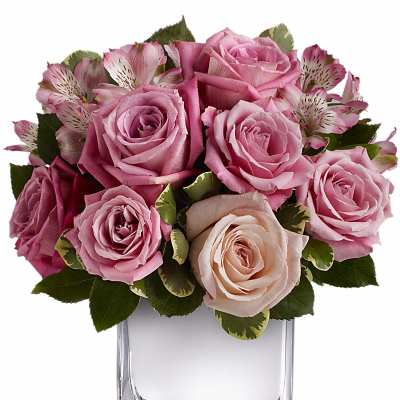 Pink roses and alstroemeria arranged in a clear glass vase