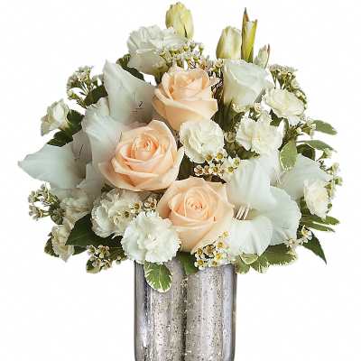 Peach roses and white flowers arranged in a silver vase