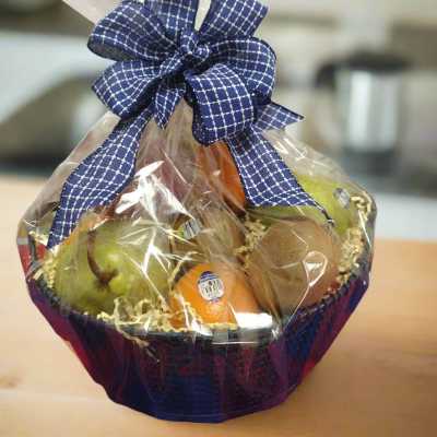 Fruit basket wrapped in clear cellophane with a blue ribbon