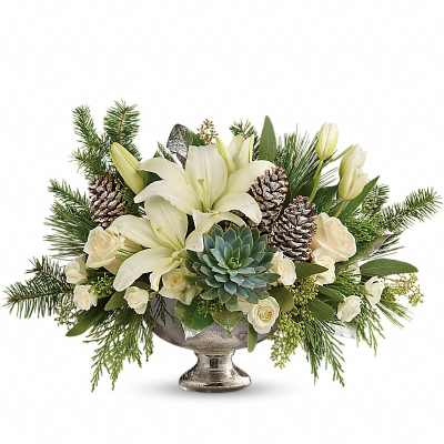 White lilies and roses arranged with pinecones in a silver pedestal bowl