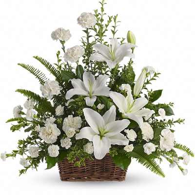 White lilies and carnations arranged in a wicker basket