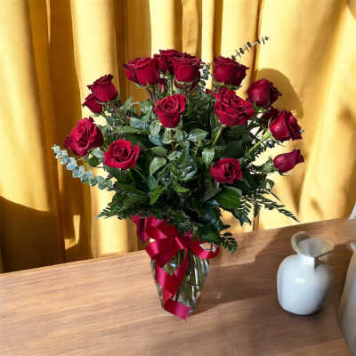 Bouquet of red roses in a glass vase with a ribbon