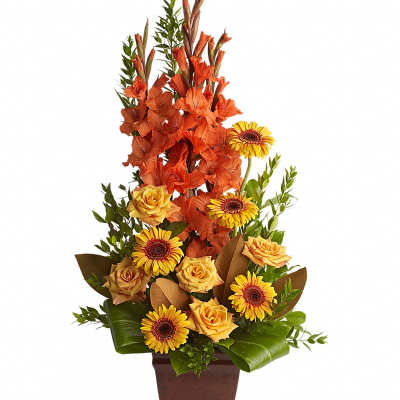 Tall orange and yellow floral arrangement in a brown vase