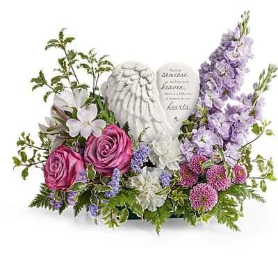 Sympathy floral arrangement with roses, lilies, and a memorial heart plaque