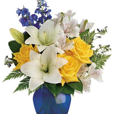 Bouquet of yellow roses, white lilies, and blue flowers in a blue vase