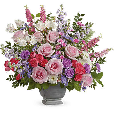 Mixed pink and purple flower arrangement in a gray urn vase
