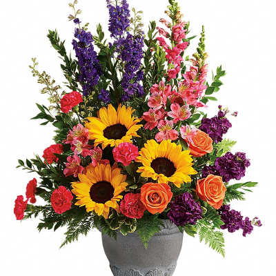 Colorful mixed flower arrangement in a gray urn vase