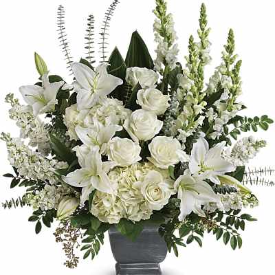 White lilies and roses arranged in a gray urn vase
