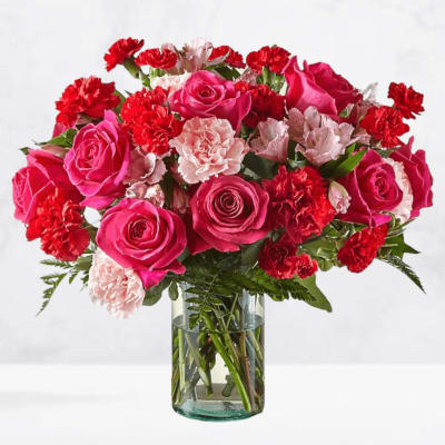 Pink roses and red carnations in a clear glass vase