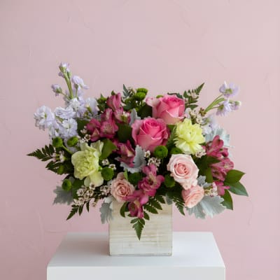 Pink and white mixed flower arrangement in a wooden box