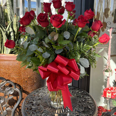 Bouquet of red roses in a glass vase with a red ribbon