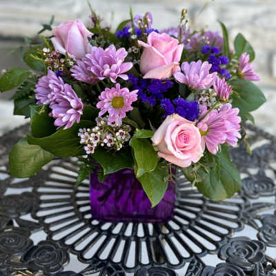Pink roses and lavender daisies in a purple vase