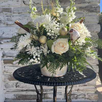 White floral arrangement with cream roses in a decorative pot