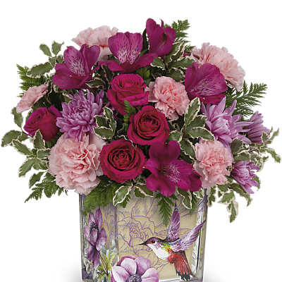 Pink and magenta bouquet in a square glass vase with hummingbird artwork