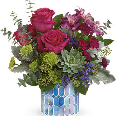 Pink roses and mixed flowers in a blue mosaic vase