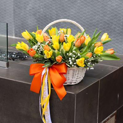 Basket of yellow and orange tulips with a large orange ribbon