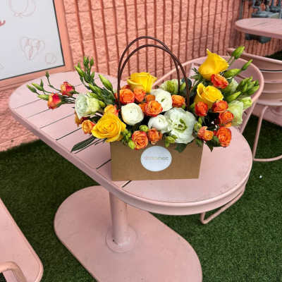 Yellow and orange roses in a brown handled box