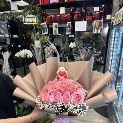 Pink rose bouquet with a small teddy bear and baby’s breath