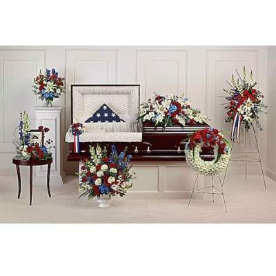 Sympathy floral set with red, white, and blue arrangements around a casket