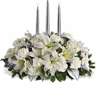White floral centerpiece with three tall silver candles